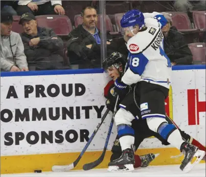  ?? CHERIE MORGAN/Special to The Okanagan Weekend ?? Penticton Vees defenceman Carson Kosobud (18) knocks down a West Kelowna Warriors player in a battle along the boards during BCHL action at the South Okanagan Events Centre in Penticton on Friday night. The Vees won 7-2.