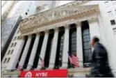  ?? RICHARD DREW — THE ASSOCIATED PRESS ?? A pedestrian passes the New York Stock Exchange. Companies including banks and technology and health care firms fell Wednesday after U.S. stocks had surged the day before.