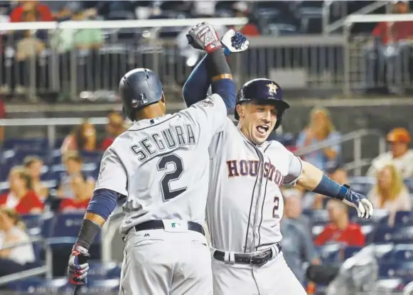  ?? Rob Carr, Getty Images ?? Houston’s Alex Bregman, right, celebrates with Seattle’s Jean Segura after hitting a solo home run in the 10th inning to put the American League up 7-6 against the National League during the All-Star Game on Tuesday night. Segura hit a two-run shot in the eighth inning.