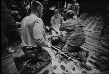  ?? SHAH MARAI, AFP/GETY Image
s ?? U.S. airmen and soldiers treat a patient on an HC-130 Hercules aircraft
during a medical evacuation at Camp Bastion, Afghanista­n.