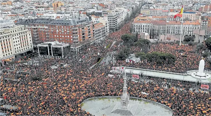  ?? AFP ?? Rojo y amarillo. Miles de personas con la bandera de España llegaron a la Plaza Colón, en Madrid, para exigir al gobierno de Pedro Sánchez que cumpla sus promesas.