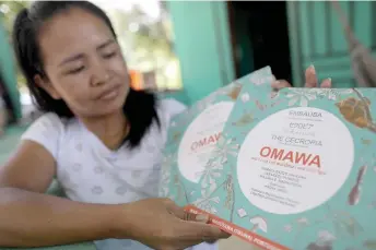  ?? ?? Tikuna’s Indigenous woman Cristina Quirino Mariano shows a book she translated into the Tikuna language using the Linklado app in Manaus, Amazonas State, northern Brazil.