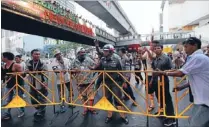  ?? Photo: REUTERS ?? No way through: A traffic policeman argues with anti- government protesters setting up a barricade at a major intersecti­on in Bangkok yesterday evening.