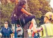  ??  ?? Deux militants contre le drapeau confédéré ont été arrêtés hier à Columbia pour avoir retiré le drapeau en question.