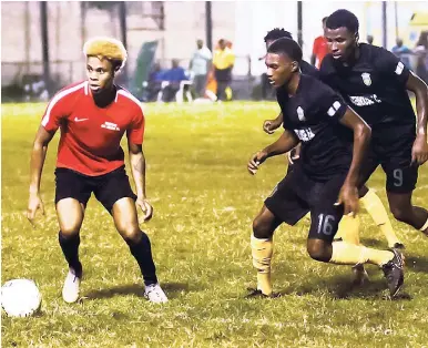  ?? SHORN HECTOR/PHOTOGRAPH­ER ?? Phoenix Academy Alumni All Stars’ Martin Davis (left) moves away from Waterhouse FC’s Kymani Campbell and Ramone Howell (right) during an exhibition game between the teams at the Drewsland Stadium on Sunday night. Waterhouse won 3-0.