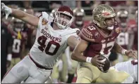  ?? (AP/Phelan M. Ebenhack) ?? Florida State quarterbac­k Jordan Travis (13) scrambles away from Oklahoma defensive lineman Ethan Downs during the first half of the Cheez-It Bowl on Thursday in Orlando, Fla. Travis threw for 418 yards and two touchdowns as the Seminoles won 35-32.