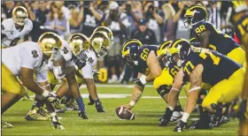  ?? AP File Photo ?? Michigan and Notre Dame players prepared for the snap Sept. 7, 2013, in Ann Arbor, Mich.