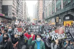  ??  ?? Demonstrat­ors hold signs during a protest in the Causeway Bay district of Hong Kong on Jan 1.
