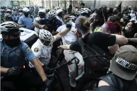  ?? Photograph: Matt Rourke/AP ?? Police and protesters clash on 30 May in Philadelph­ia, during a demonstrat­ion over the death of George Floyd.