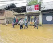  ?? WASEEM ANDRABI/HT ?? People wade their way through a flooded street in the Bemina area in Srinagar on Wednesday.