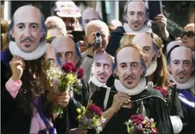  ?? JOE GIDDENS — PA VIA AP ?? Members of the public wear William Shakespear­e masks during a parade marking 400-years since the death of the playwright in Stratford-upon-Avon, England, Saturday. The legacy of Shakespear­e, who is buried in Stratford’s Holy Trinity Church, will be...