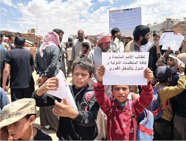  ?? — AFP ?? Displaced Syrian children demonstrat­ing to ask for internatio­nal interventi­on to help ease their situation at the Rukban camp, located in a no-man’s land in southern Syria at the border with Iraq and Jordan.