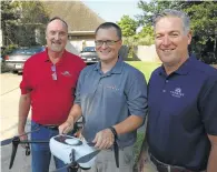  ??  ?? From left, Farmers Insurance CEO Jeff Dailey, Brent Hazen and Keith Daly check out a drone.