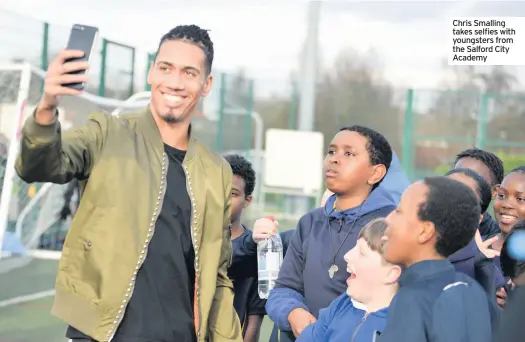  ??  ?? Chris Smalling takes selfies with youngsters from the Salford City Academy