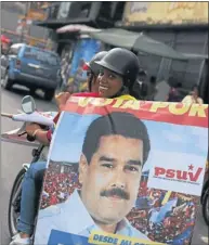  ?? Picture: REUTERS ?? CAMPAIGN TRAIL: A woman holds a banner of Venezuela’s presidenti­al candidate Nicolas Maduro this week. Venezuelan­s will hold presidenti­al elections on Sunday.