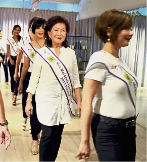  ??  ?? Still going strong: Ng (second from right) participat­ing in a catwalk rehearsal with the other pageant finalists.