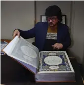  ?? — AFP ?? In this file photo, Afghan master miniature artist Mohammad Tamim Sahibzada shows a handmade Quran made with silk fabric at the Turquoise Mountain Foundation in Mourad Khani, in the old city section of Kabul.