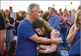  ?? GREG LOVETT / THE PALM BEACH POST ?? Ron Weinberg hugs his 13-year-old daughter Alexis on Thursday as they attend a candleligh­t memorial service for victims of the mass shooting at Marjory Stoneman Douglas High.