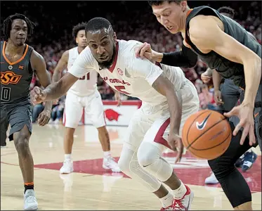  ?? NWA Democrat-Gazette/CHARLIE KAIJO ?? Arkansas forward Arlando Cook (middle) attempts to steal the ball from Oklahoma State forward Lindy Waters during the Razorbacks’ 66-65 victory over the Cowboys at Walton Arena in Fayettevil­le on Saturday. The Razorbacks finished with nine steals, led...