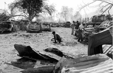  ?? AP PHOTOS ?? People look for salvageabl­e items at a car mechanic shop that was set on fire during gang violence in Port-auPrince, Haiti, on Monday, March 25, 2024.