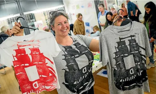 ?? AIMAN AMERUL MUNER/STUFF ?? Helen Oishi with some of the limited edition printed T-shirts at the Parents Art Collective Timaru’s print-making and scavenger hunt in Timaru on Saturday.
