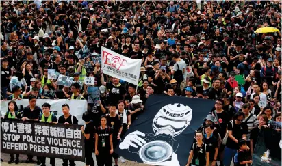  ?? (Tyrone Siu/Reuters) ?? JOURNALIST­S AND supporters for press freedom wear black as they stage a silent march in Hong Kong yesterday to denounce media treatment during a protest against the proposed extraditio­n bill.