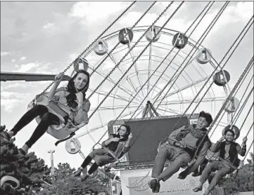  ?? RAHMAT GUL/AP PHOTOS ?? Since mid-July, Afghans can do things like celebrate marriages in wedding halls. Above, visitors on a park ride in Kabul.