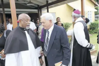  ?? (Photos: Norman Thomas) ?? Rev Fr Franklyn Jackson, pastor at Church of St Margaret’s (left), having a private word with Carlton Paterson, widower of Winsomepat­erson at the end of the service of thanksgivi­ng.