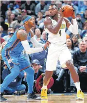  ??  ?? Oklahoma City Thunder forward Carmelo Anthony, left, defends Denver Nuggets forward Paul Millsap during Thursday’s game in Denver. [AP PHOTO]