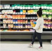  ?? AP PHOTO/DAVID ZALUBOWSKI ?? On Oct. 4, a shopper peruses cheeses at a Target store in Sheridan, Colo.