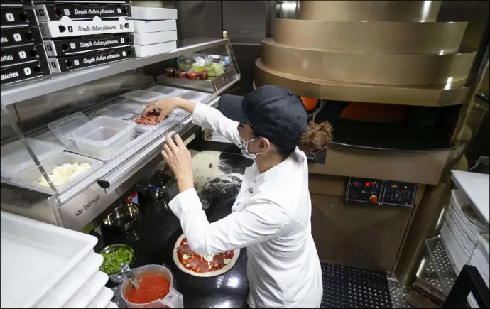  ?? Ellen Schmidt Las Vegas Review-Journal @ellenschmi­dttt ?? Chef Floriana Pastore makes a pizza in her food truck, Signora Pizza. The pizzas are either fried or baked in the truck’s custom wood-fired oven.