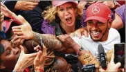  ?? MARK THOMPSON / GETTY IMAGES ?? Race winner Lewis Hamilton of Mercedes GP celebrates with fans after the F1 Grand Prix of Great Britain at Silverston­e on Sunday.