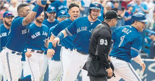  ?? FRED THORNHILL/THE CANADIAN PRESS ?? The Jays pour on to the field to celebrate with Justin Smoak, third from right, who scored the winning run on a bases-loaded walk to teammate Luke Maile.