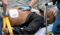  ??  ?? Khalid Masood receives medical attention after being shot by police following his deadly rampage at Westminste­r Bridge and the Houses of Parliament.