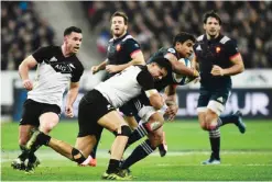  ?? — AFP ?? PARIS: France’s centre Wesley Fofana (2nd R) is tackled by New Zealand’s winger Julian Savea (C) during the rugby union Test match between France and New Zealand on Saturday, at the Stade de France in Saint-Denis, near Paris.