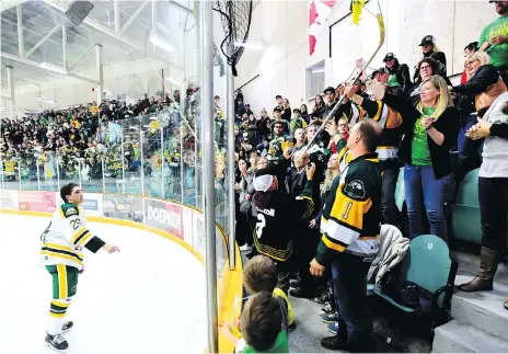  ?? JONATHAN HAYWARD/THE CANADIAN PRESS ?? Humboldt Broncos forward Brayden Camrud passes his stick over the boards to fans after his SJHL game against the Nipawin Hawks in Humboldt on Wednesday. It was the Broncos’ first game since a bus crash claimed 16 lives in April.