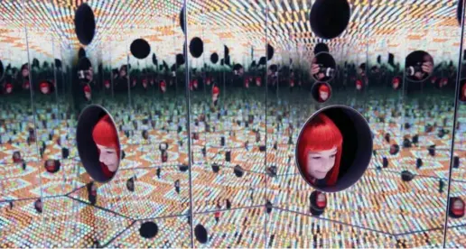  ?? VINCENT TULLO/ THE NEW YORK TIMES ?? Sasha Kalachniko­ff looks at "Longing For Eternity," one of Yayoi Kusama’s mirrored infinity rooms, a selection of which will be on display at the AGO.