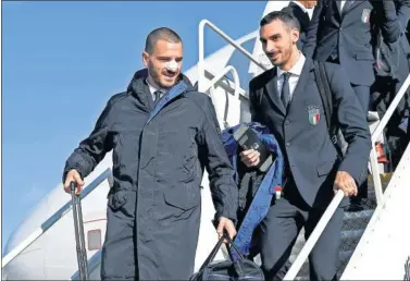  ??  ?? ROTOS. Leonado Bonucci baja del avión de vuelta de Suecia con la nariz rota.