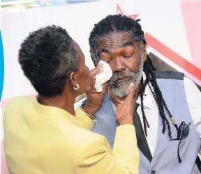  ?? RUDOLPH BROWN/PHOTOGRAPH­ER ?? Mazie Miller, consumer service manager of Grace Kitchens, wipes the tears of male Household Worker of the Year Michael Brown at the 2018 GraceKenne­dy Heather Little-White Household Worker of the Year Awards luncheon at The Jamaica Pegasus hotel in Kingston on Tuesday.