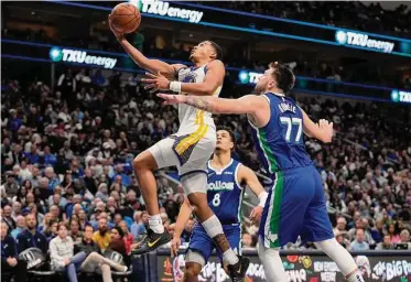  ?? Photos by Tony Gutierrez/Associated Press ?? Warriors guard Jordan Poole soars past Luka Doncic for two of his nine points against the Mavericks.