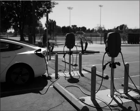  ?? JAE C. HONG / ASSOCIATED PRESS ?? Electric vehicle chargers are seen in the parking lot of South El Monte High School in South El Monte, Calif. The state is speeding away from gas-powered vehicles, with its mandate for all vehicles to be zero-emissions by 2035, and the market boom that is expected to create will force other states to catch up.