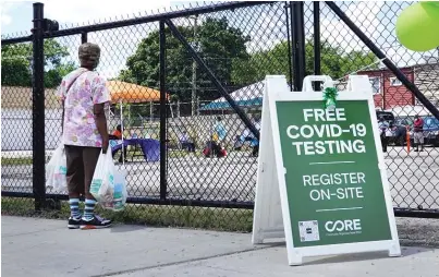  ?? SCOTT OLSON/GETTY IMAGES ?? In this photo from June 2020, a sign alerts residents to a mobile COVID-19 testing site set up on a vacant lot in predominan­tly Black Austin. Black and Latino Chicagoans have been disproport­ionately hard hit by the pandemic.