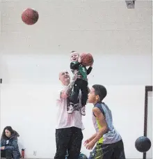  ??  ?? St. Catharines CYO atom co-coach Kevin McKenna Jr. helps his son Kyrie, 2, reach the net during a recent practice.