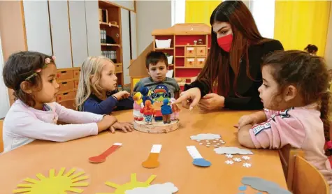  ?? Foto: Silvio Wyszengrad ?? Erzieherin Paraskevi Anagnostop­oulou wird ab sofort Maske tragen müssen, wenn sie mit den Kindern ihrer Einrichtun­g spielt. Dies ist eine von vielen Regeln, die nun in Augs‰ burg greifen.