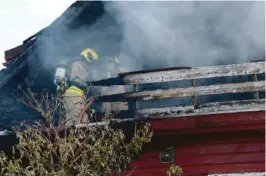  ??  ?? PÅ VEI INN: Brannfolke­ne gikk inn for å sjekke om det var noen i huset.