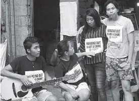  ?? MICHAEL VARCAS ?? Members of the Akbayan Youth group bear signs denouncing the crackdown against tambays in Quezon City yesterday.