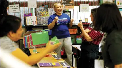  ?? PHOTO VINCENT OSUNA ?? Presenter Elizabeth Raygoza (middle) smiles as parents participat­e in an interactiv­e activity during El Centro Elementary School District’s annual Parent Fair on Saturday at Sunflower Elementary School in El Centro.