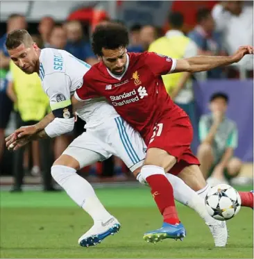  ?? FOTO: RITZAU SCANPIX ?? Real Madrids hårde hund, Sergio Ramos, har her godt fat i Liverpools målmaskine, Mohamed Salah. Ramos traekker egypteren med ned. Salah lander på venstre skulder og må lade sig udskifte kort efter med en skade.