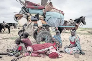  ?? REUTERS ?? A Sudanese family who fled the conflict in Murnei in Sudan’s Darfur region, sit beside their belongings in Adre, Chad.