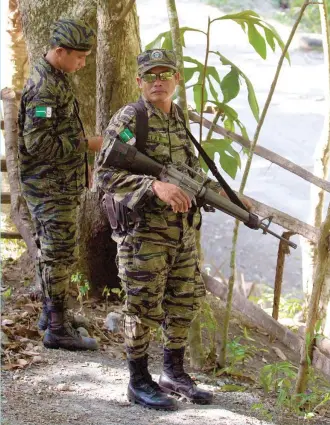  ??  ?? Two Moro Islamic Liberation Front soldiers stand guard on a village near their camp in Maguindana­o province in southern Philippine­s.